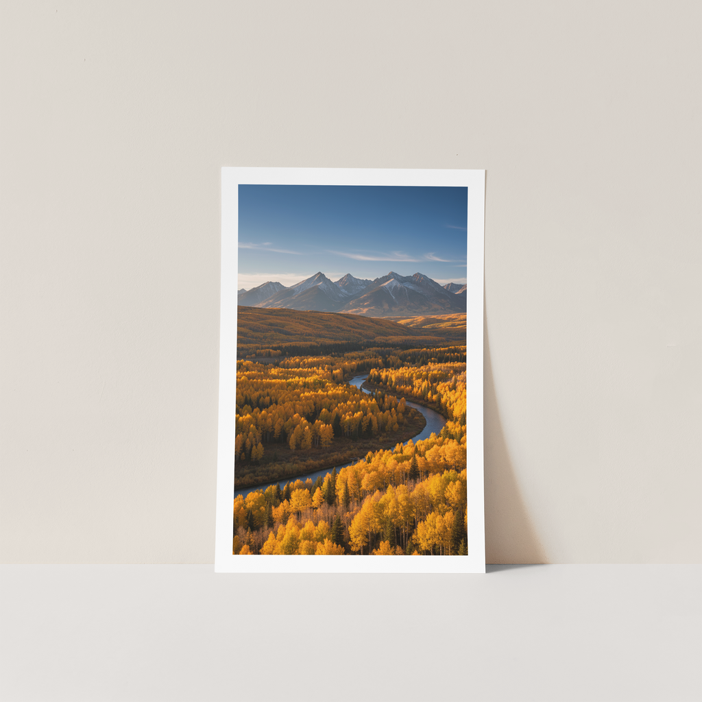 Framed print of a mountain landscape with autumn trees on a white wall.