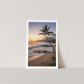 Framed artwork of a tropical sunset with palm tree on a beach.